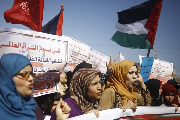 Perempuan Palestina memegang bendera nasional saat berdemonstrasi di Gaza City dalam memperingati Hari Perempuan Internasional pada 9 Maret 2017. Mohammed Abed/AFP 