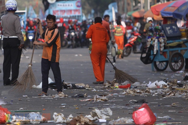 Petugas Sibuk Bersihkan Sampah Sisa Demo Buruh