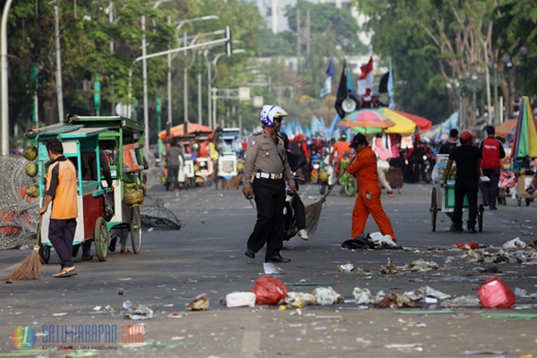 Petugas Sibuk Bersihkan Sampah Sisa Demo Buruh