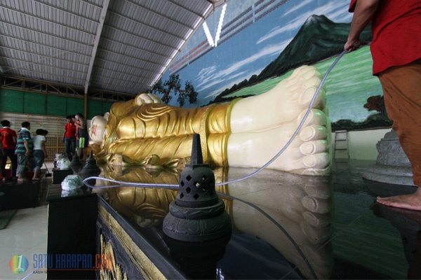 Jelang Imlek Patung Budha Tidur Dimandikan